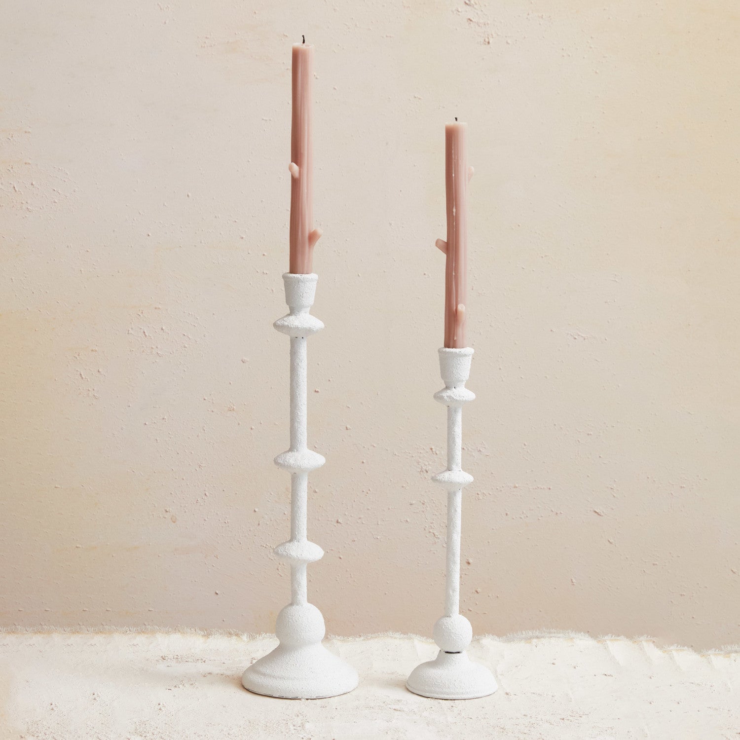 Two white metal taper holders with a sand finish, displayed against a neutral background.